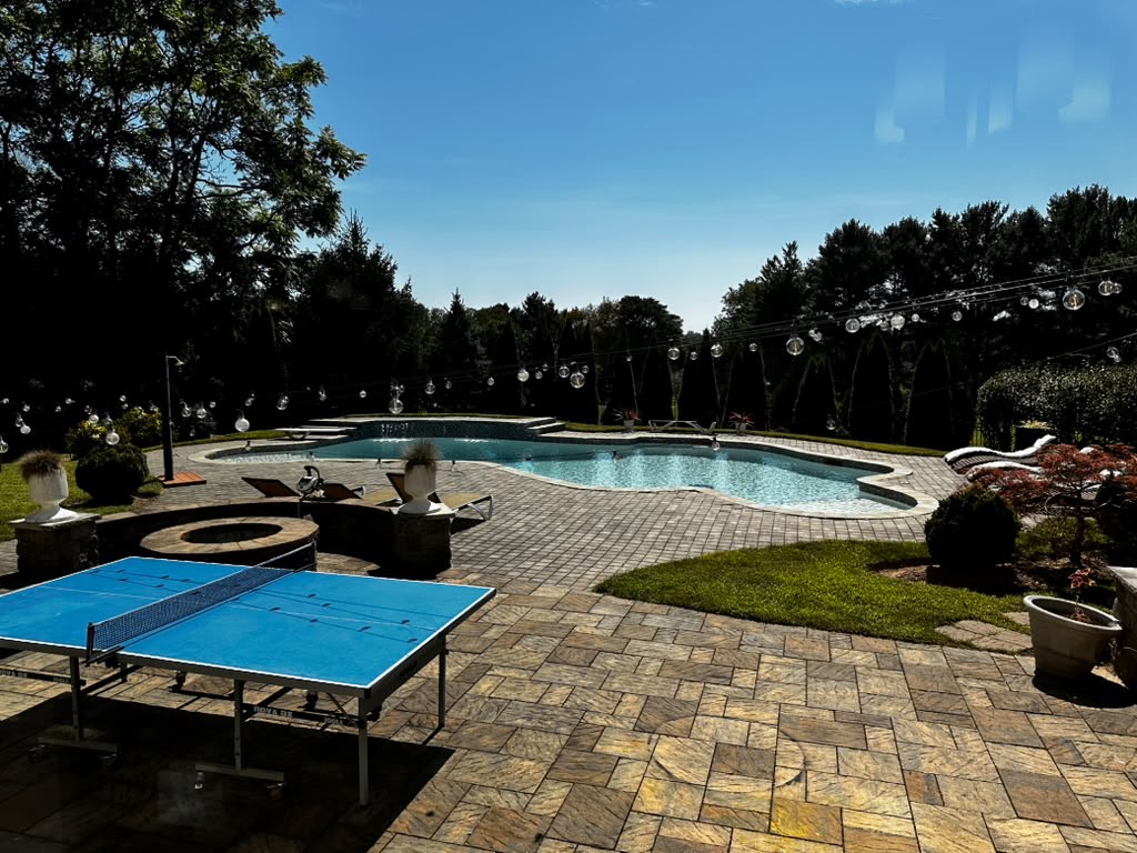 Outdoor patio with pool and ping pong table for recreation